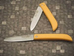 دختری با چاقو شکاری تاشو برای دوستش لباس زیبایی برش کرد